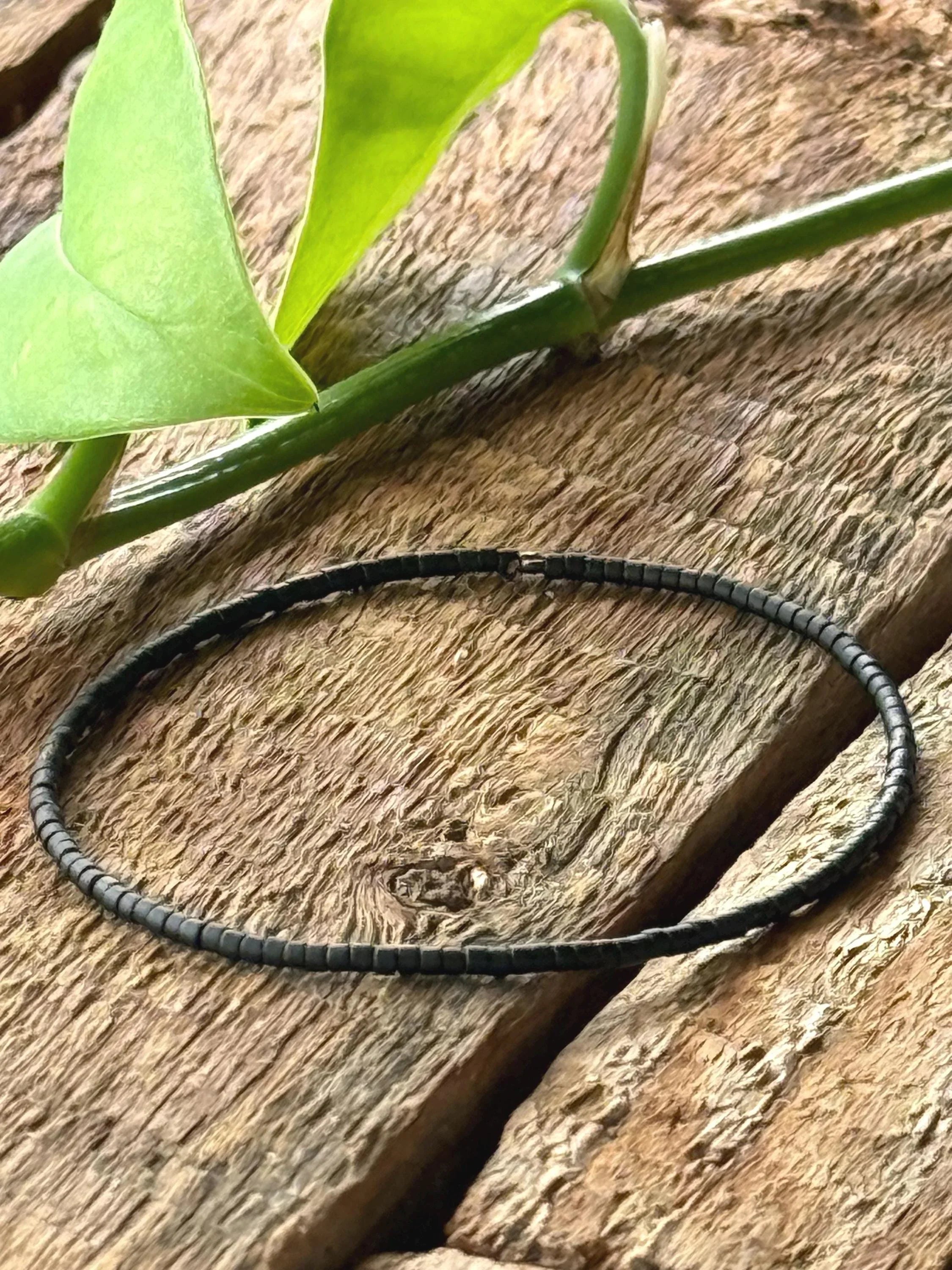Handmade black glass seed bead bracelet on rustic wood, Seed and Soul artistry jewelry