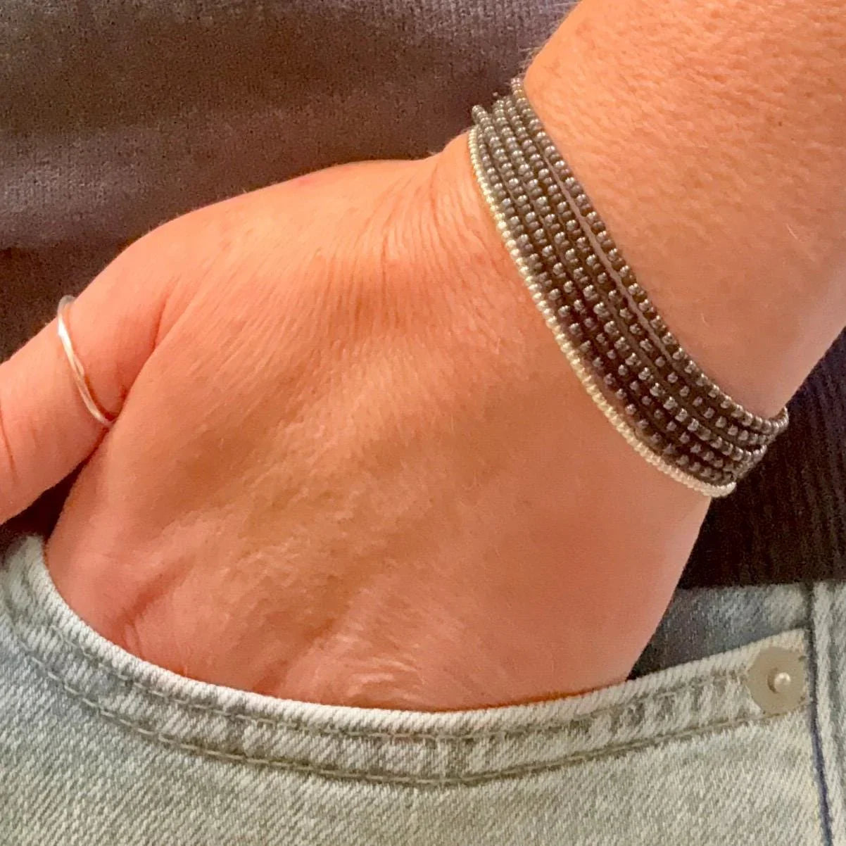 Hand wearing handmade glass seed bead bracelet, Seed and Soul artistry jewelry