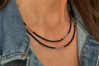 Close-up of a neck wearing handmade glass seed bead necklace with brown and turquoise beads, styled with denim jacket