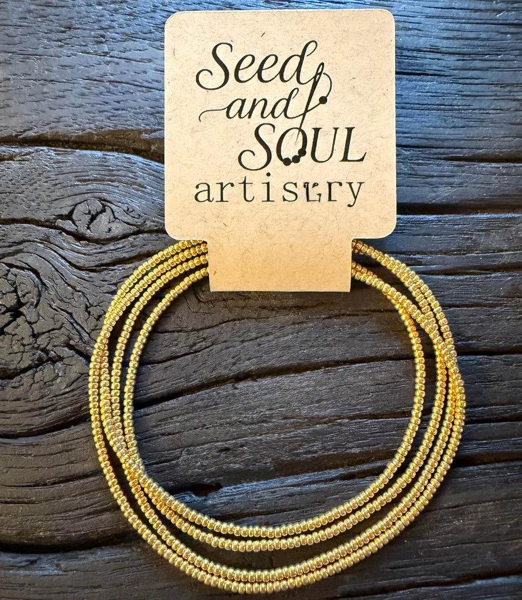 Handmade gold glass seed bead bracelet by Seed and Soul artistry on rustic wood background