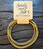 Handmade gold glass seed bead bracelet by Seed and Soul artistry on rustic wood background