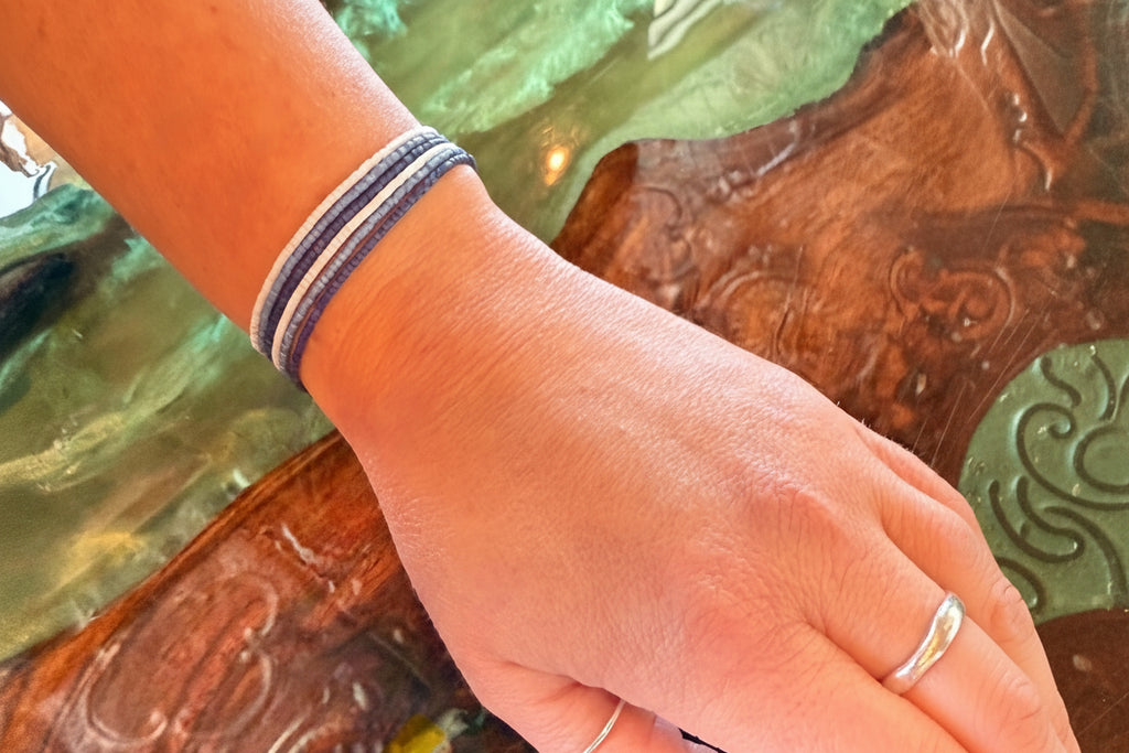 Hand wearing handmade glass seed bead bracelet in three shades of blue, Seed and Soul artistry jewelry