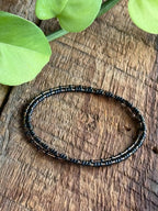 Handmade black glass seed bead bracelet on rustic wood, Seed and Soul artistry jewelry