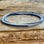 Handmade glass seed bead bracelet in blue and white on rustic wood, Seed and Soul artistry jewelry