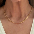 gold seed bead necklace worn on woman's neck