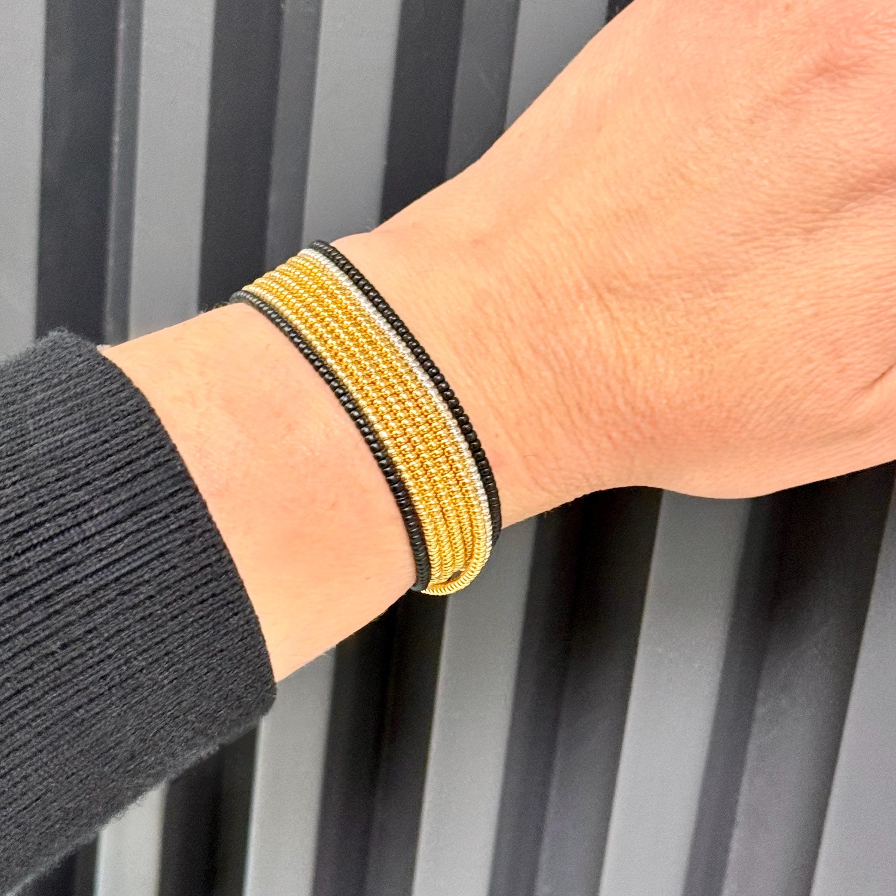 Hand wearing handmade gold and black glass seed bead bracelet by Seed and Soul artistry