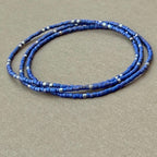 Handmade glass seed bead bracelets with matte blue and silver beads on gray background