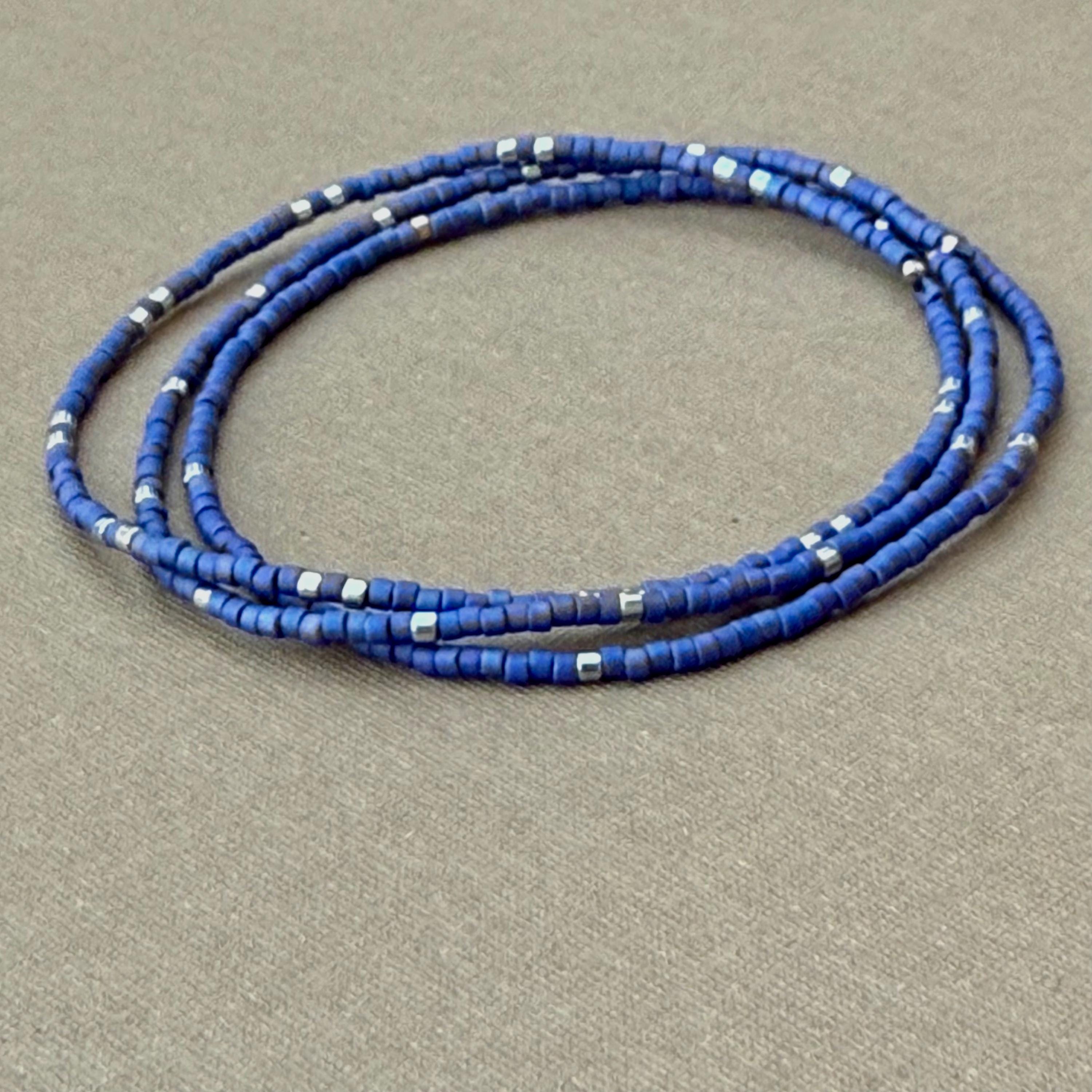 Handmade glass seed bead bracelets with matte blue and silver beads on gray background