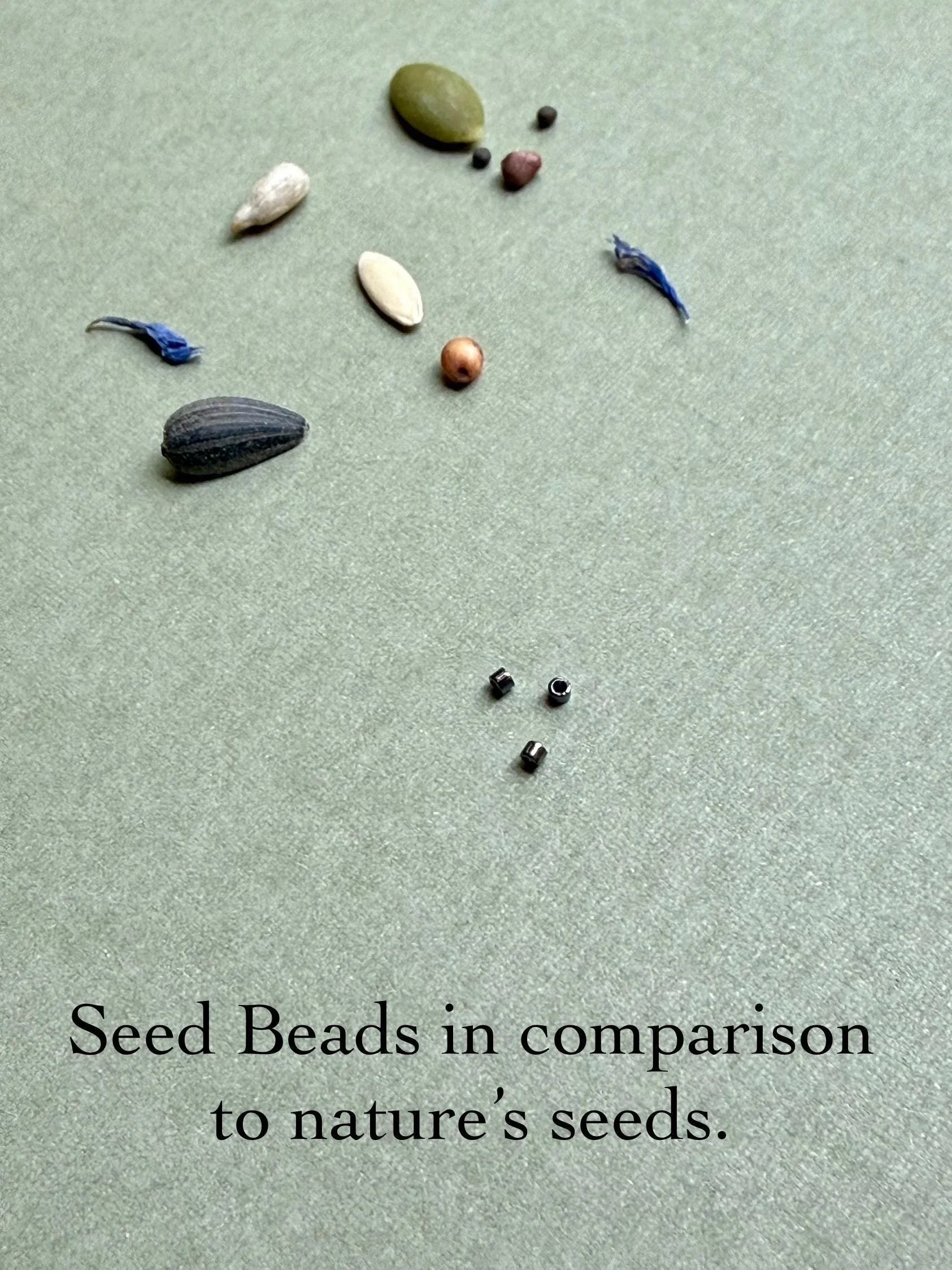 Glass seed beads and natural seeds on textured background, Seed and Soul artistry handmade jewelry