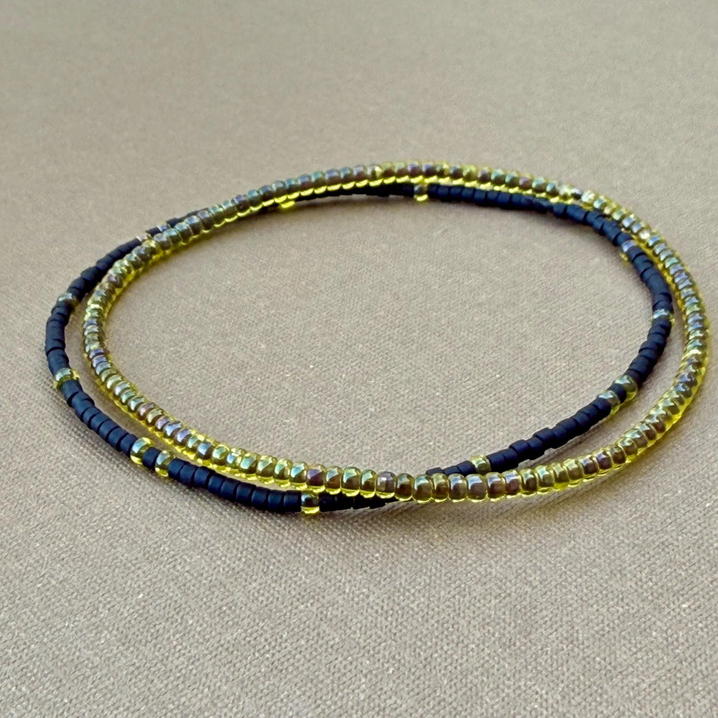 Handmade glass seed bead bracelet set of two in yellow and black on tan background