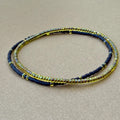 Handmade glass seed bead bracelet set of two in yellow and black on tan background