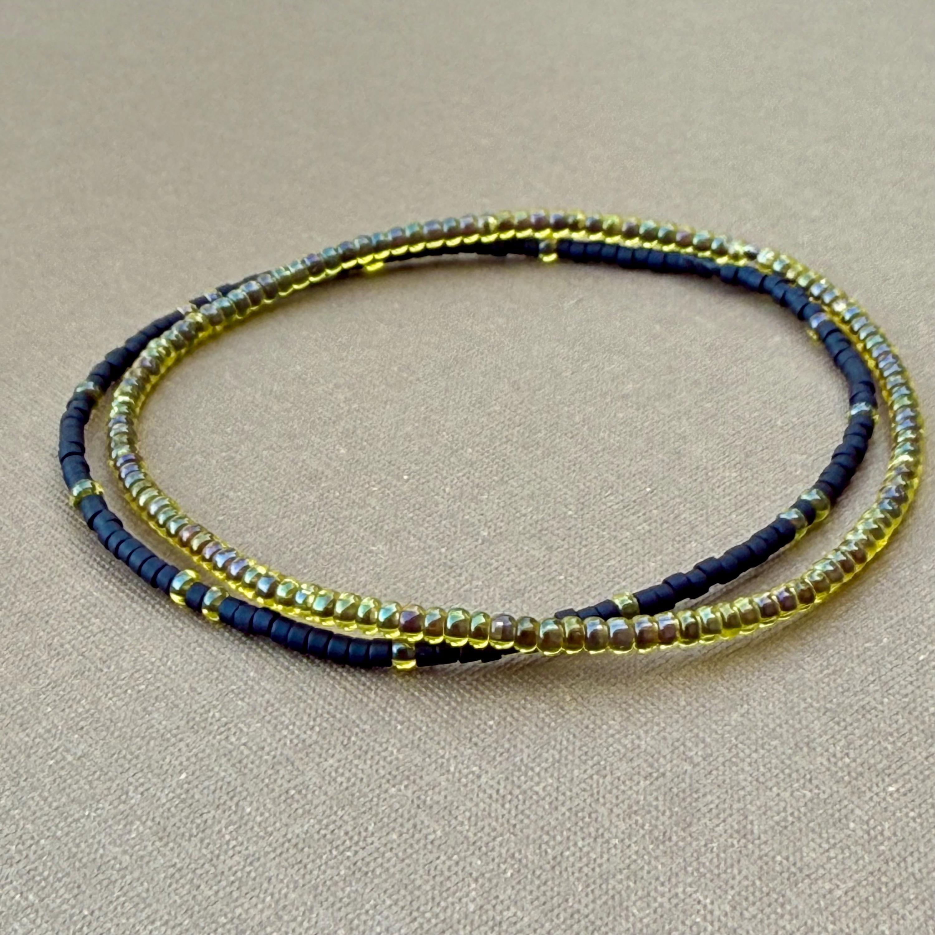Handmade glass seed bead bracelet set of two in yellow and black on tan background