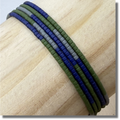 Handmade glass seed bead wrap bracelet with green, blue, and gray beads on a wooden display rod