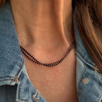 Black and copper-plated seed bead necklace displayed on a woman's neck.