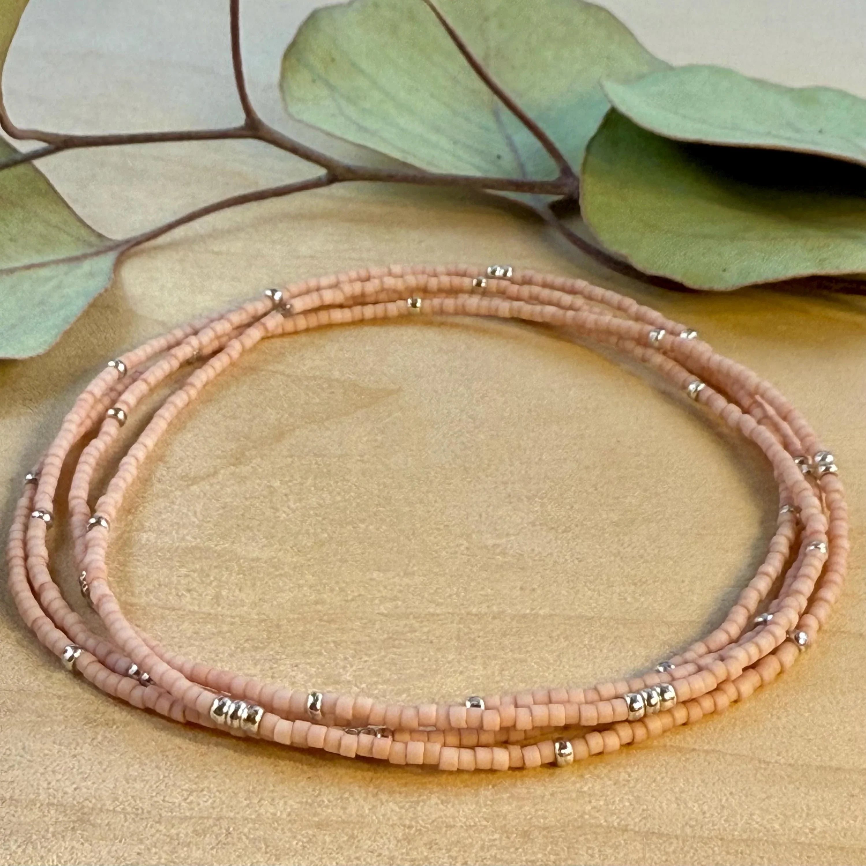 Handmade pink glass seed bead bracelet with silver accents on wood, Seed and Soul artistry