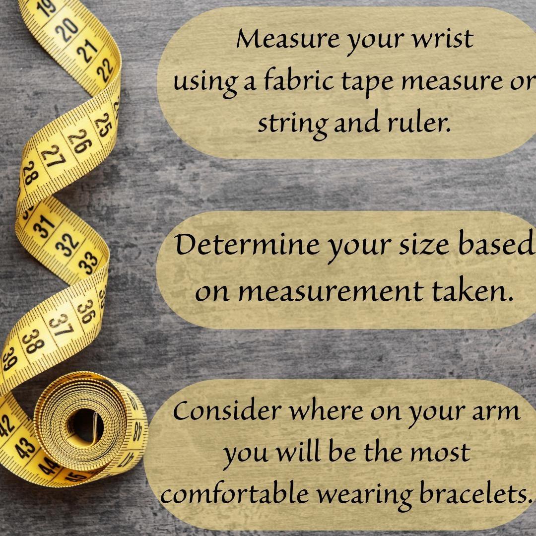 Yellow fabric tape measure on grey surface with bracelet sizing instructions for handmade jewelry.