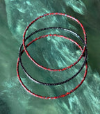 Handmade red and black glass seed bead bangles on green background, Seed and Soul artistry